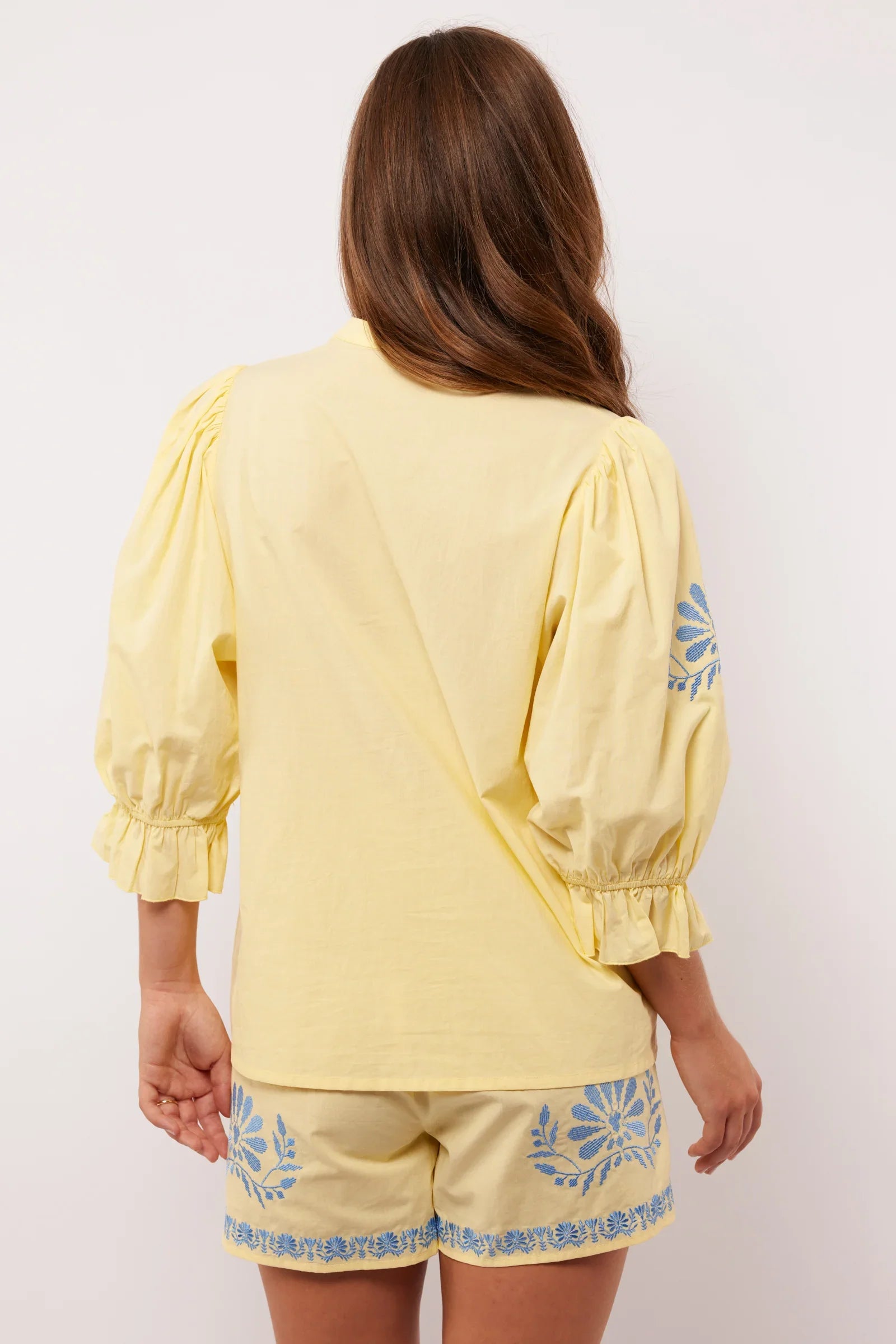 Achterkant van de Fluresk Marlowe blouse in geel met pofmouwen en bijpassende short.