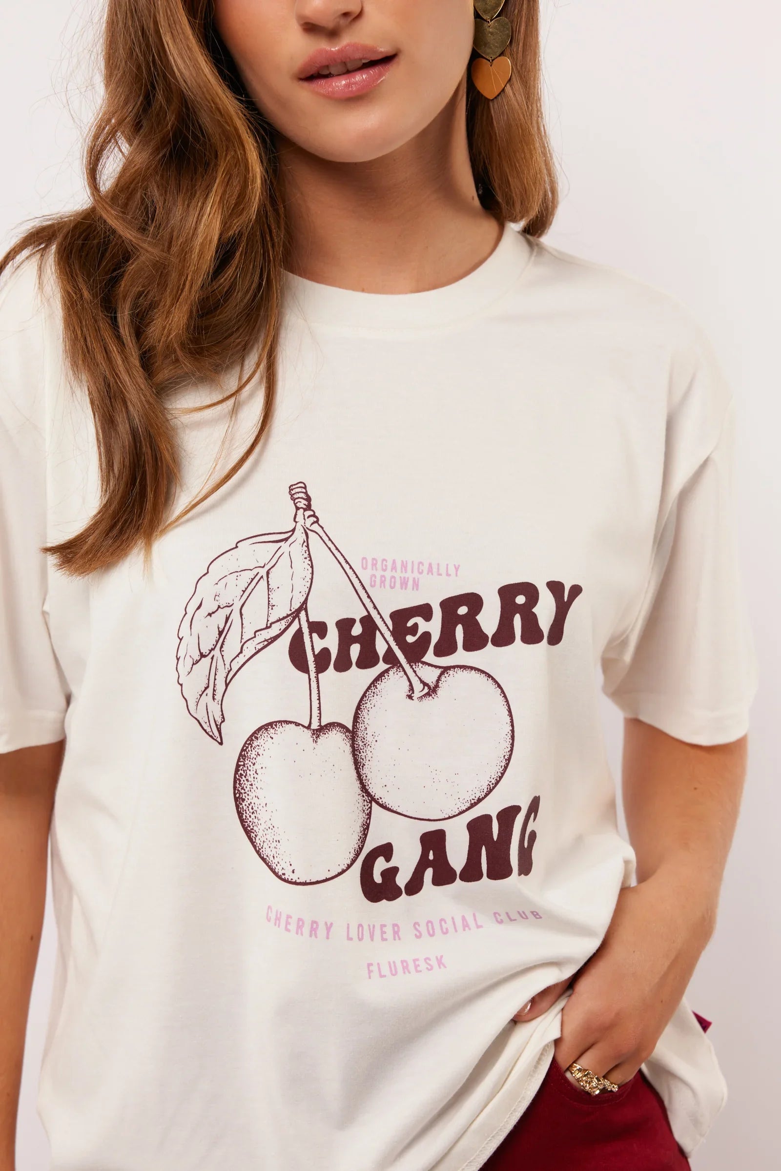 Close-up van de ‘Cherry Gang’ print op het Fluresk Miranda T-shirt met kersenillustratie.