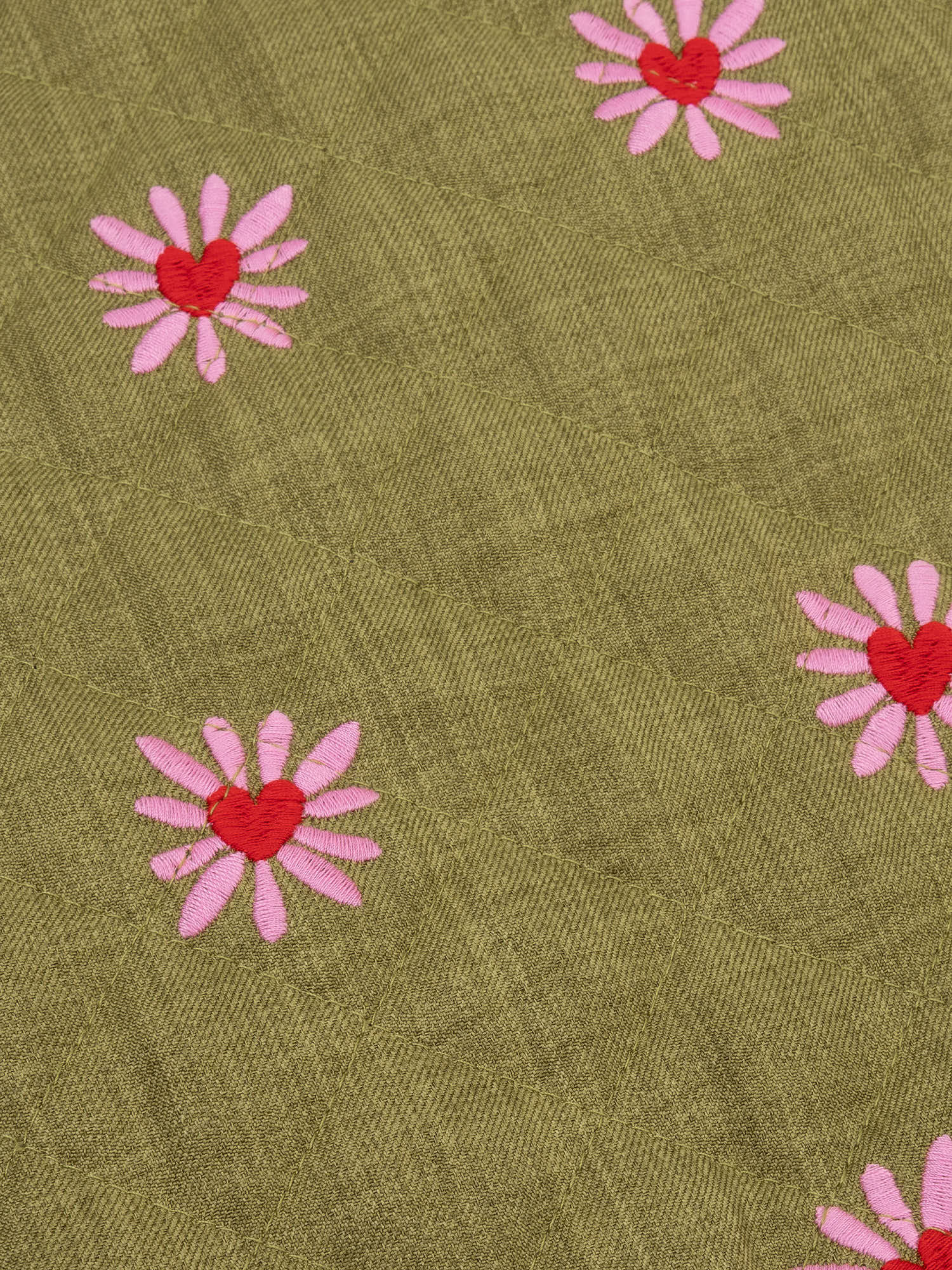 Close up van het robylin jacket van ydence in een groene kleur met rode en roze hartjes.