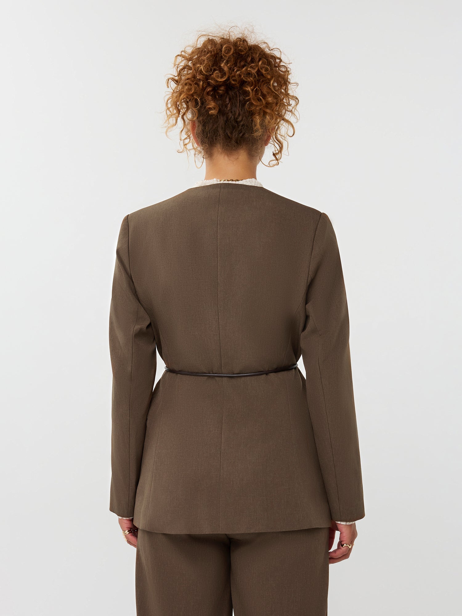 model draagt de ydence lexie blazer in de kleir mud met een zwart ceintuur, achteraanzicht.