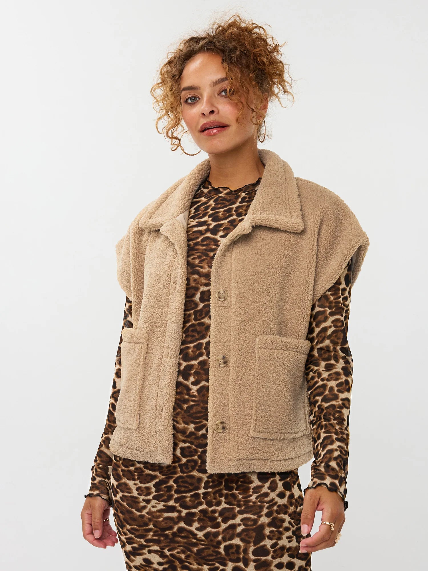 model draagt het rejou jacket van ydence open over een panterprint jurk.