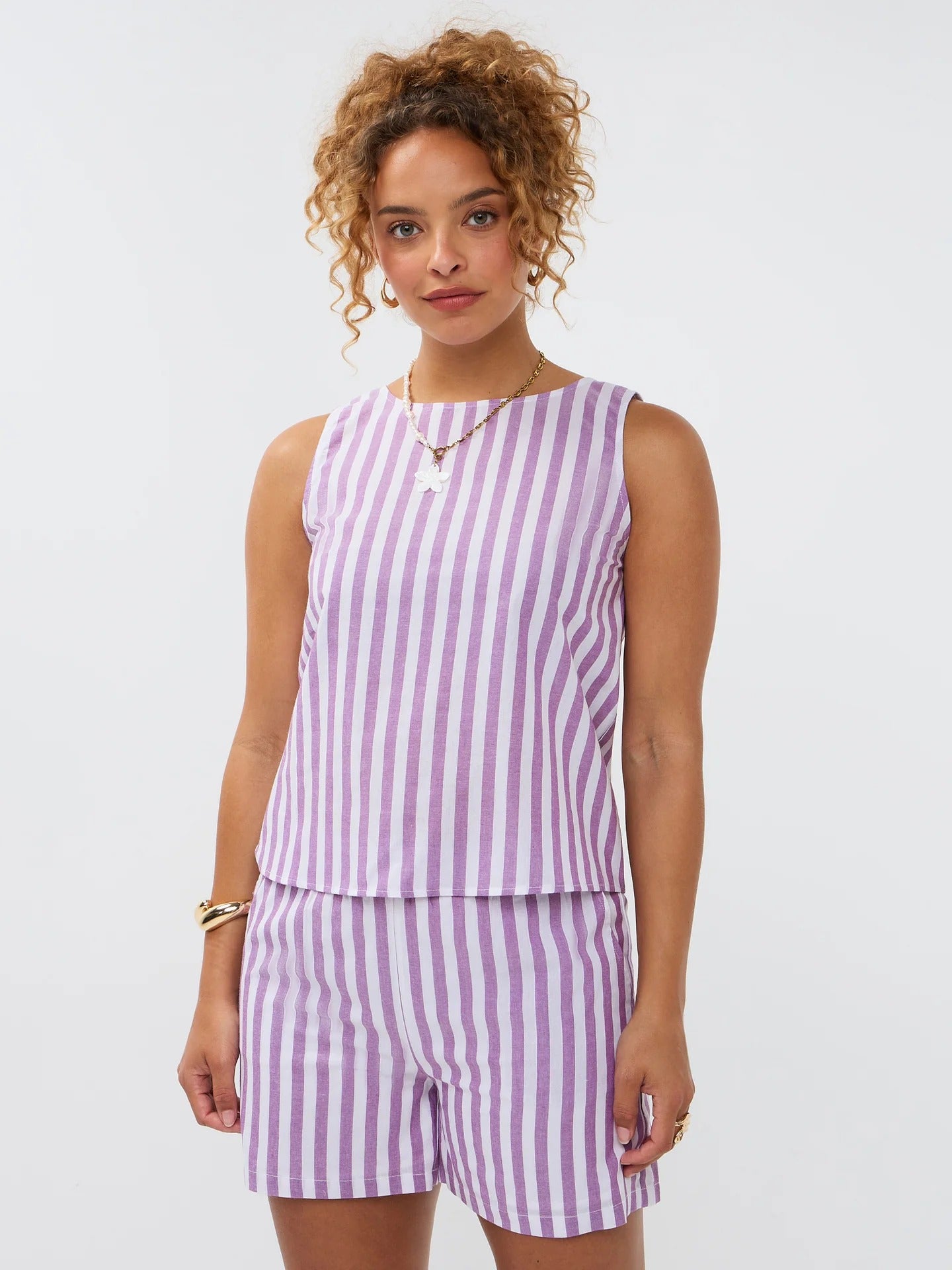 Model draagt de Arlette top en de mima short een lila-wit gestreepte mouwloze linnen top en short van Ydence.