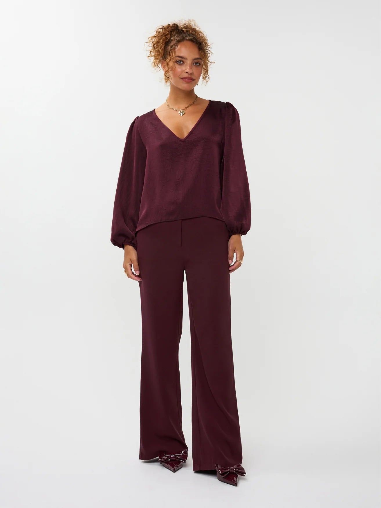 modelfoto van de solange pants van ydence in burgundy met een zelfde kleur blouse erop gecombineerd.