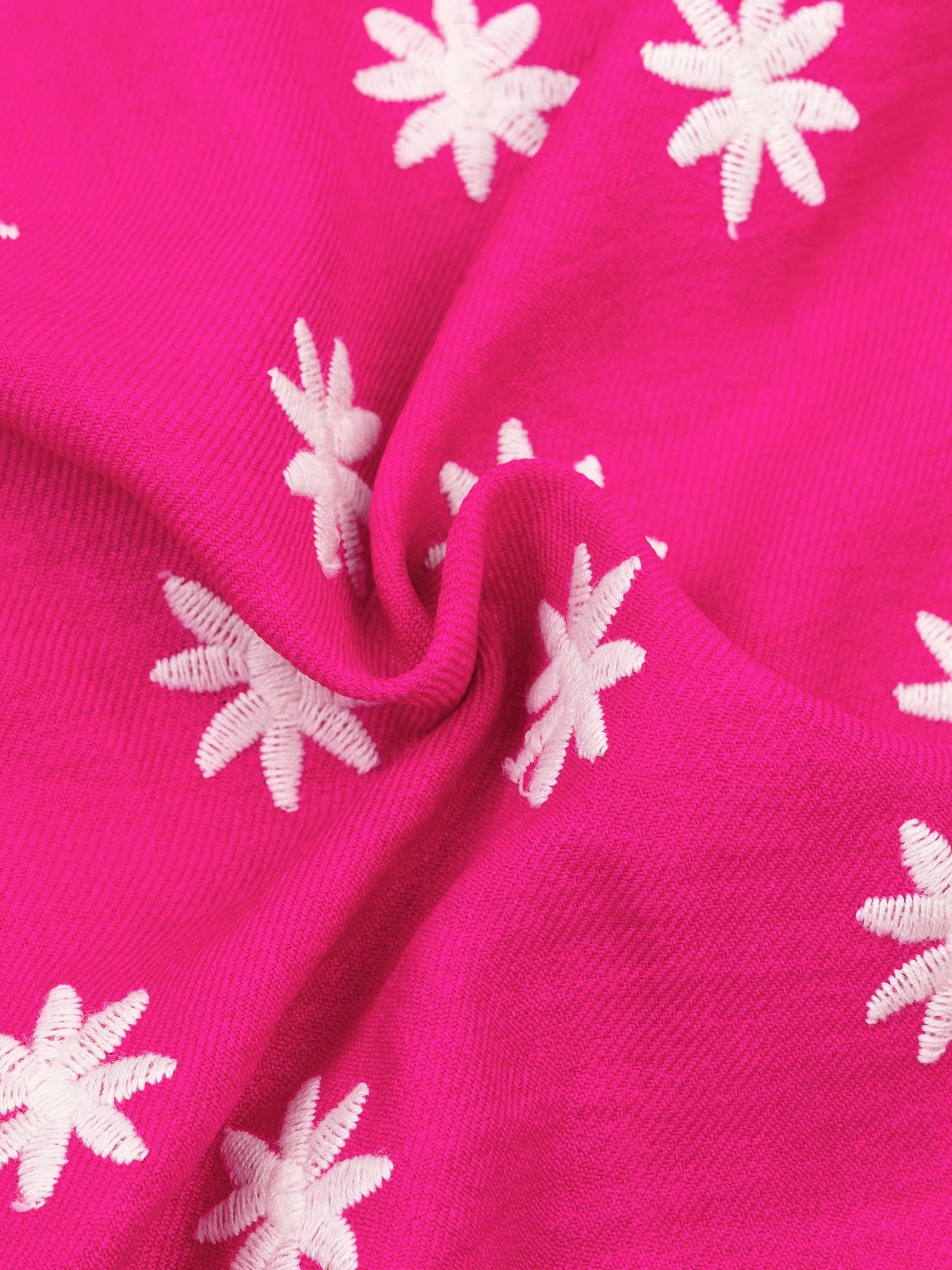 Close-up van de roze stof met witte geborduurde bloemen van de Ydence Vivienne blouse – speelse en luchtige textuur.