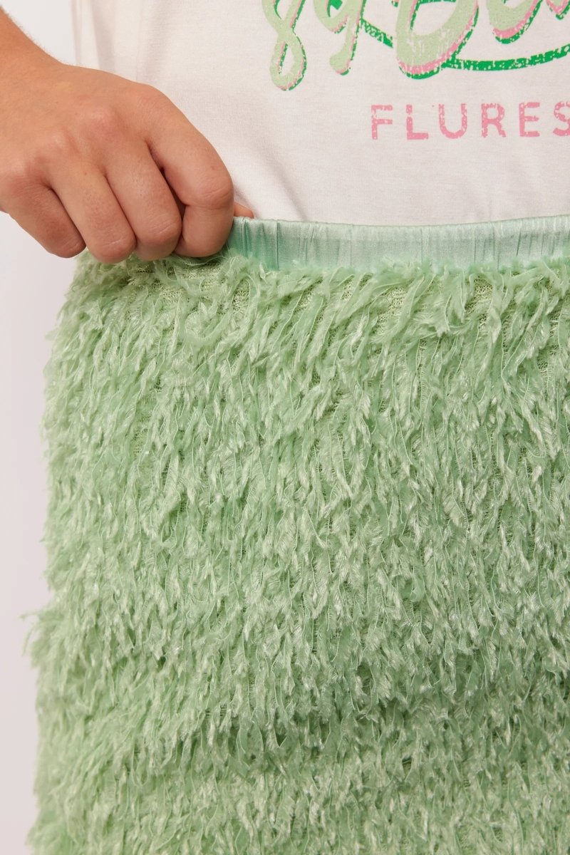 Close-up van de tailleband van de Arianne Skirt van Fluresk, met pluizige groene stof en elastische band.