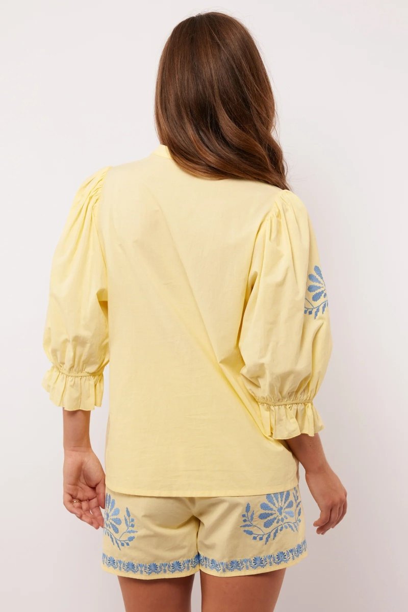 Achterkant van de Fluresk Marlowe blouse in geel met pofmouwen en bijpassende short.