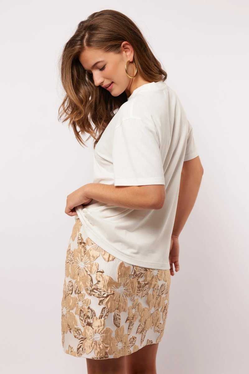 Zijaanzicht van het Soraya T-shirt gecombineerd met een glanzende bloemenrok.