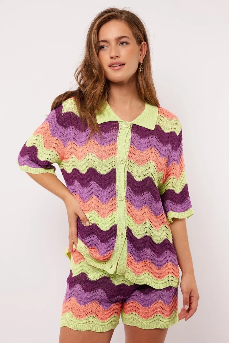 Model draagt de Whitney Blouse van Fluresk met golvend gehaakt patroon en knoopsluiting, gezien van voren.
