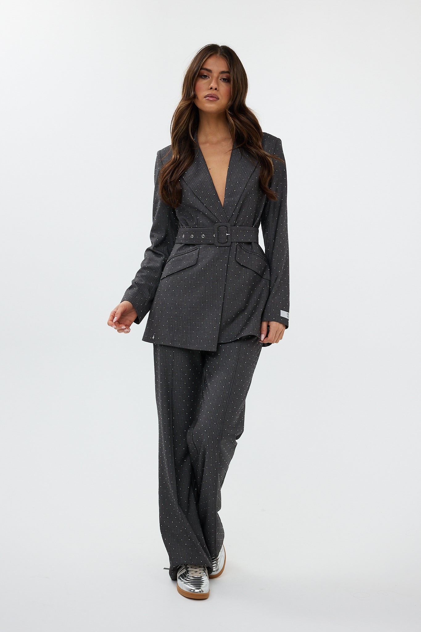 model draagt de ann trousers en de ann blazer van heyb club in grijs met steentjes.