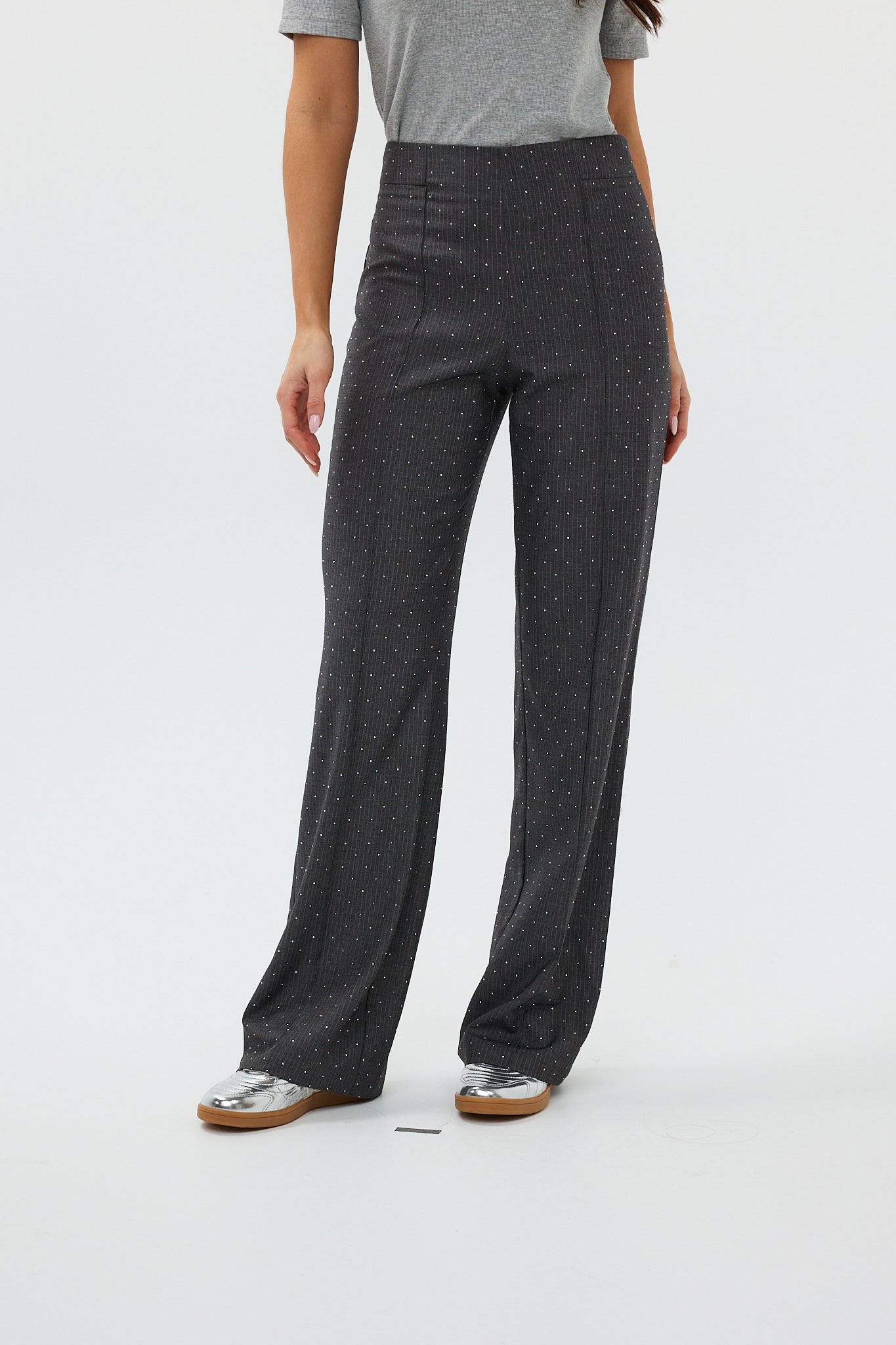 model draagt de ann trousers van heyb club in grijs met steentjes.