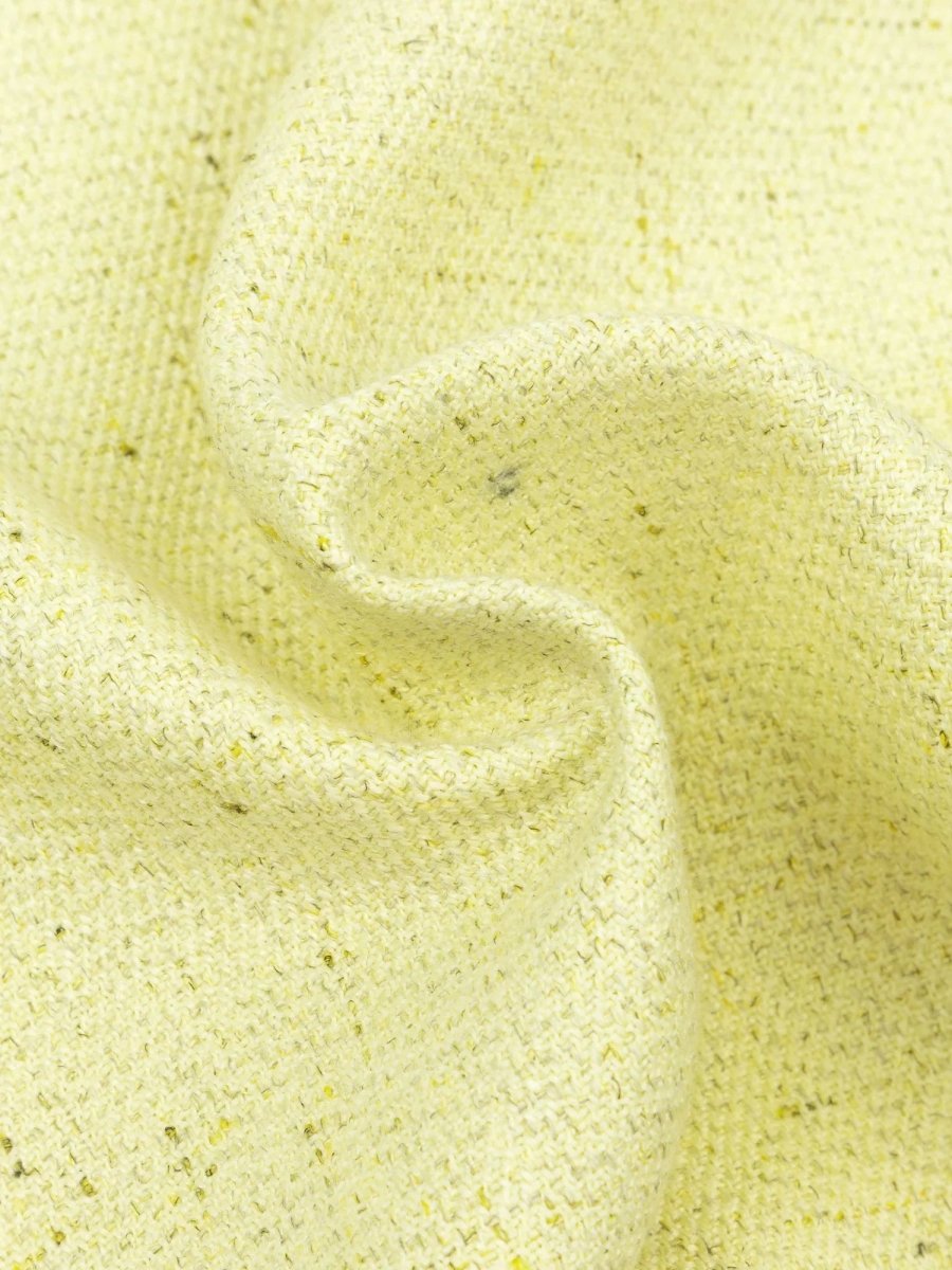 Close-up van de botergele boucléstof van het Amanda gilet van Ydence, zachte textuur en fijne structuur.