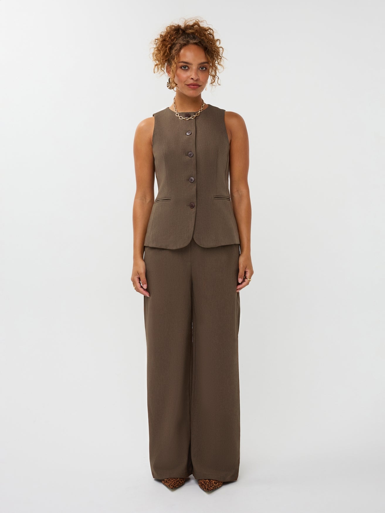 Model draagt de ydence yade pants gecombineerd met het mellie gilet in de kleur mud als co-ord set.