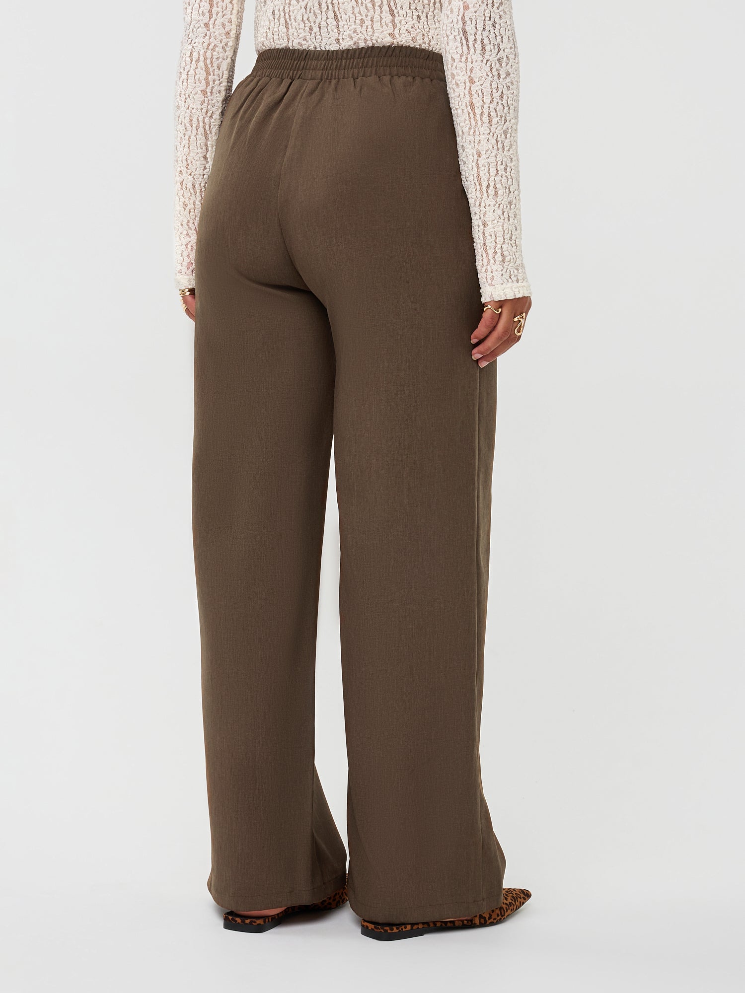 Model draagt de yade pants van ydence in de kleur mud, achter aanzicht.