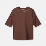 Productfoto van het bruine t-shirt plat gefotografeerd, met studs rond de hals.