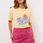 Zomerse outfit met het pastelgele Annora T-shirt van Fluresk – combineer met een roze rok voor een vrolijke look.