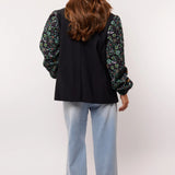 Achteraanzicht van de Fluresk Celin Pants in lichtblauwe denim met wijde pijpen.