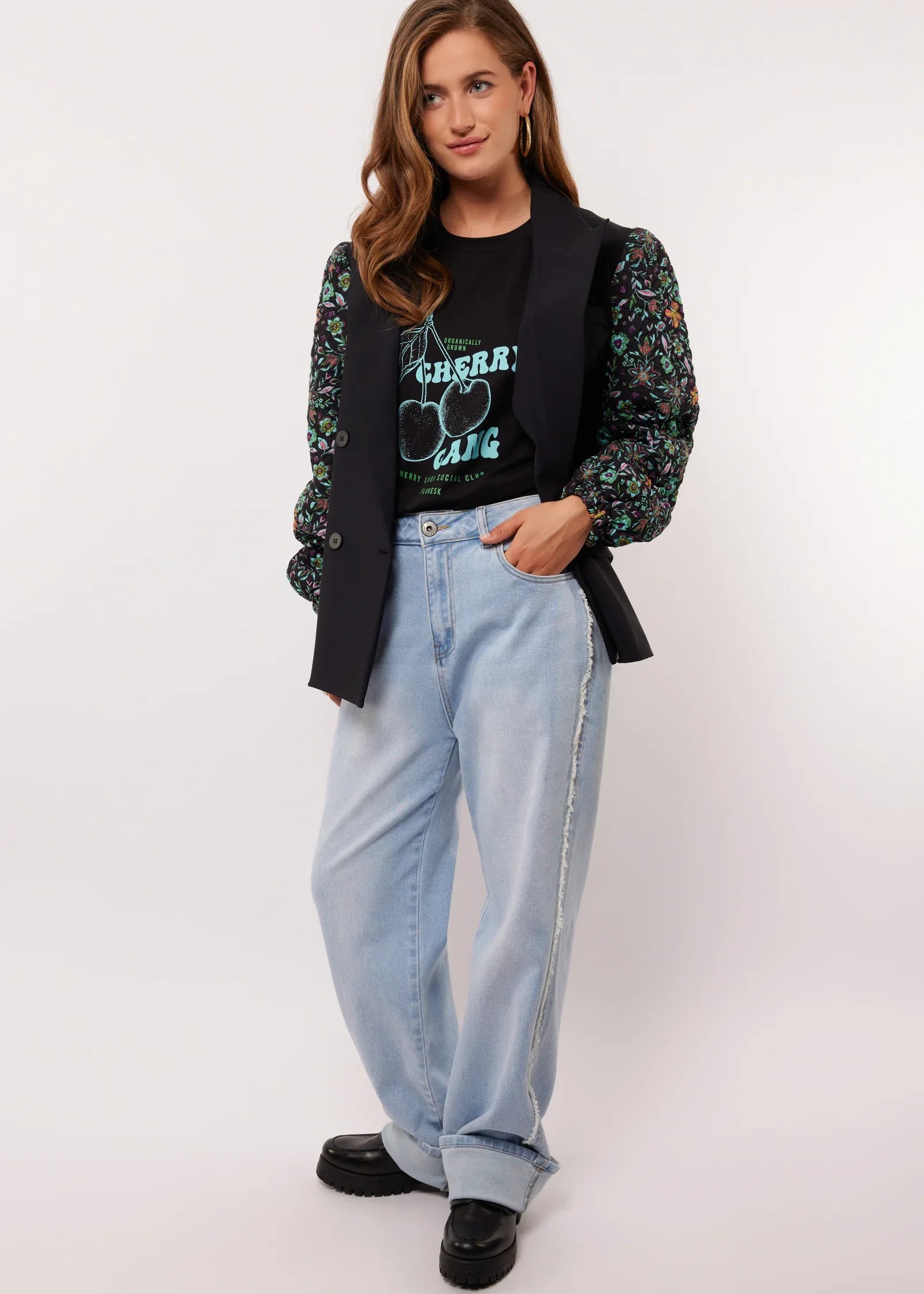 Model draagt de Fluresk Celin Pants in lichtblauw denim met een zwarte Cherry Gang top en gilet.