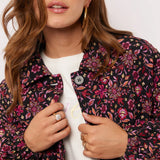 Close-up van model met Fluresk Mirabel Jacket met kleurrijke bloemenprint in roze en paars.