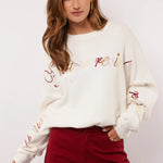 Model styled de Fluresk Veraline Sweater met een bordeauxrode wide leg broek.