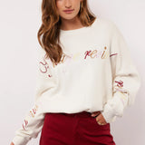 Model styled de Fluresk Veraline Sweater met een bordeauxrode wide leg broek.