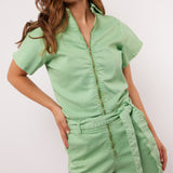 Vrouw draagt mintgroene Fluresk Idaly playsuit met rits en ceintuur, vooraanzicht.