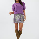 model draagt de bloom top van heyb club in paars met bloementjes.