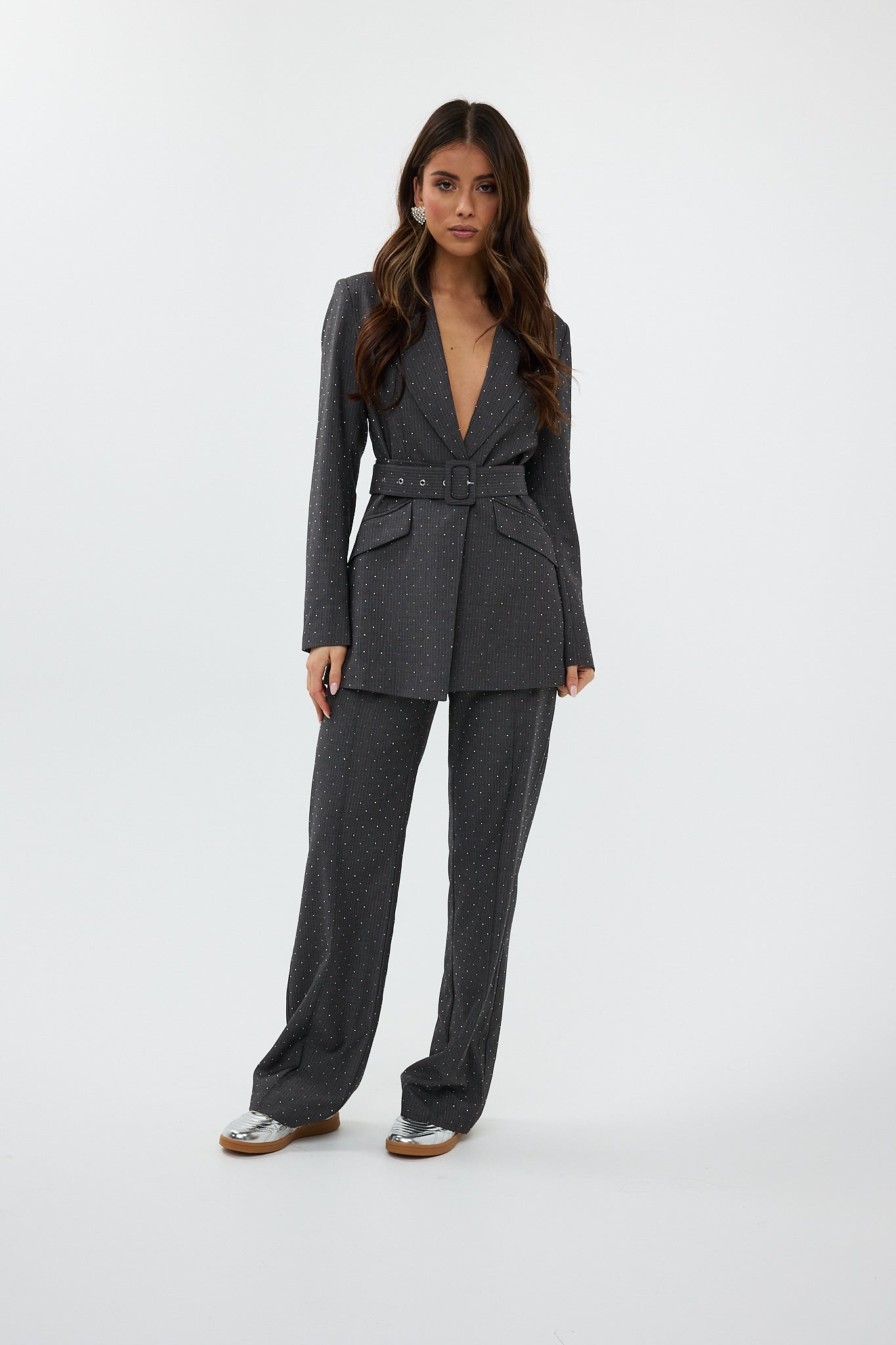 model draagt de ann trousers en de ann blazer van heyb club in grijs met steentjes.