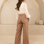 Model draagt trouser shayma in beige  met witte blouse als kantoor outfit.
