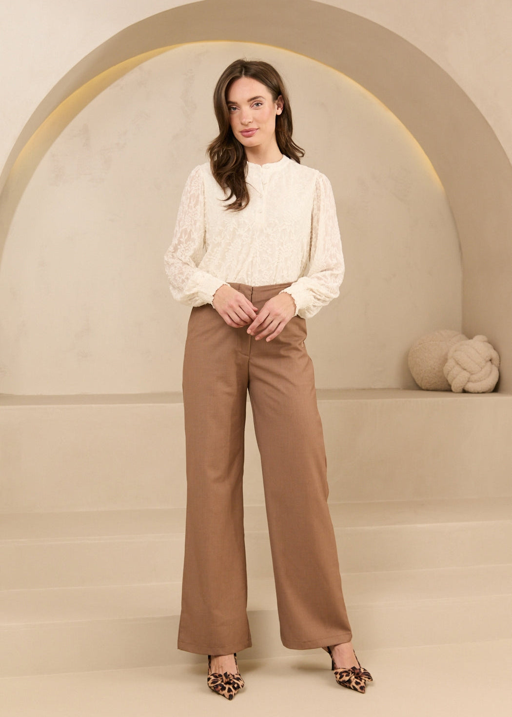 Model draagt trouser shayma met blouse als kantoor outfit.