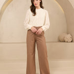 Model draagt trouser shayma met blouse als kantoor outfit.