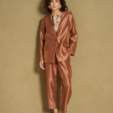 Model in caramel satijnen blazer en bijpassende broek