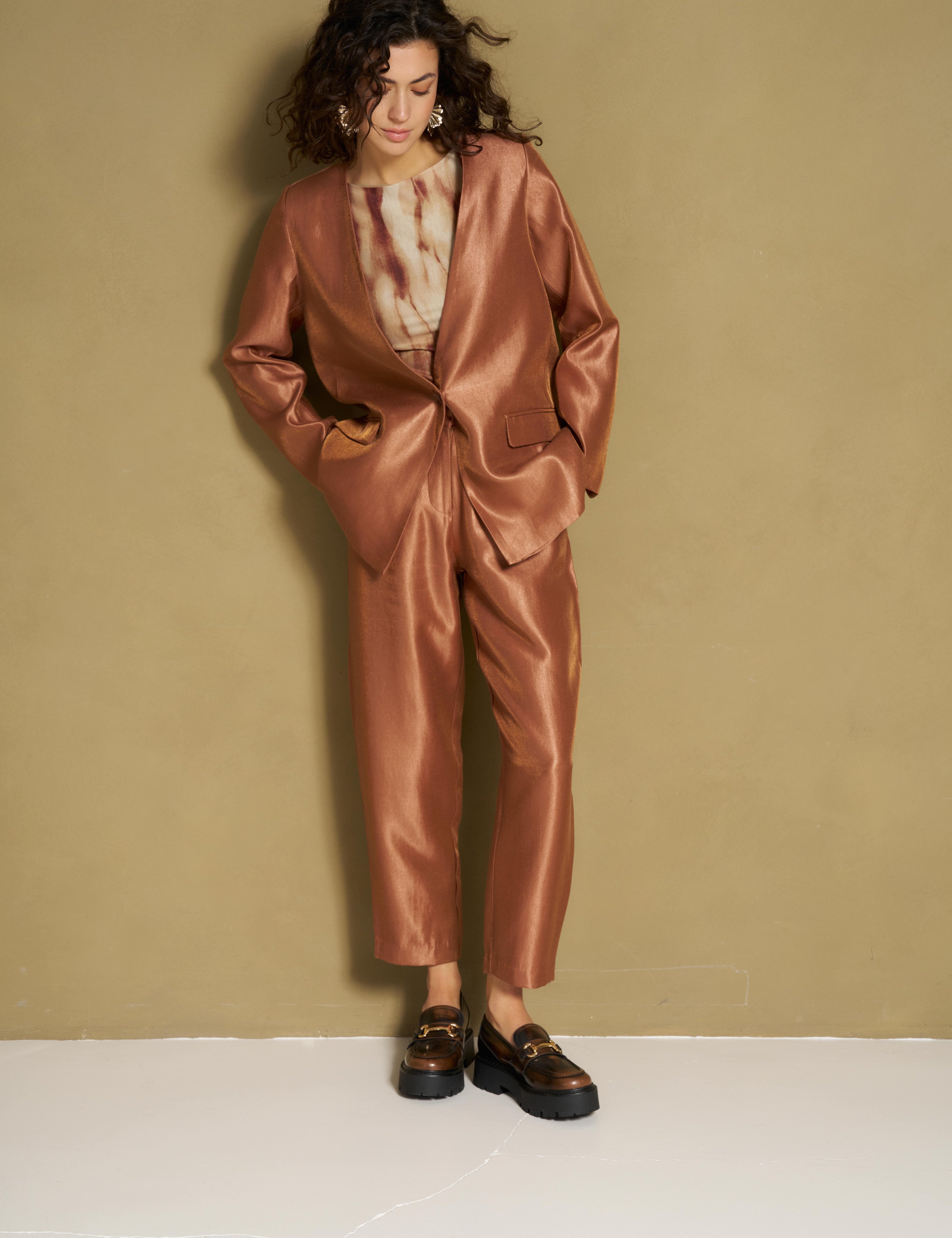 Model in caramel satijnen broek en bijpassende blazer