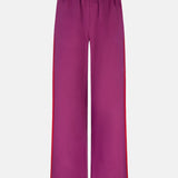 Productfoto van de voorkant van de zizi pants van ydence in fachsia met rode streep aan de zijkant.