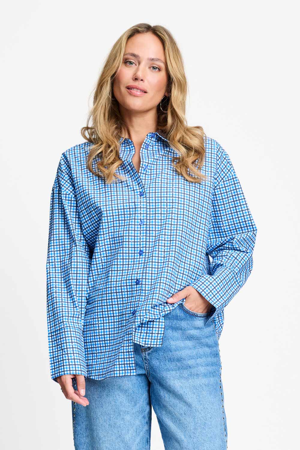 Model draagt de saffierblauwe geruite Beau Check blouse van POM Amsterdam op een lichtblauwe jeans.