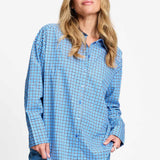Blauw geruite blouse met chocoladebruine kraag, van dichtbij op de voorkant gefotografeerd.