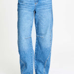 De brede pijpen van de jeans van dichtbij, gedragen op een hak.