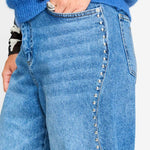 Detailfoto van de zilverkleurige studs langs de zijnaad van de jeans.