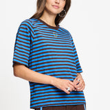 Model draagt het blauw met bruin gestreepte t-shirt Tyra van POM Amsterdam.