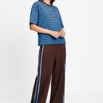 Volledige look met het gestreepte t-shirt op een bruine wijde broek.