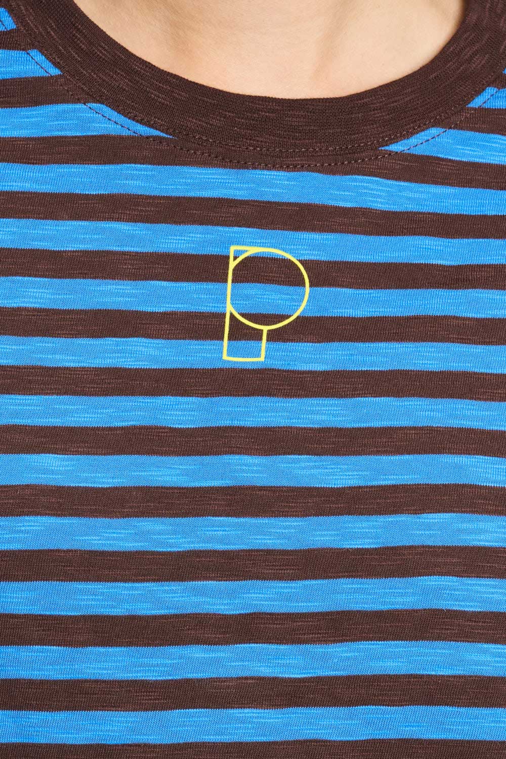 Detailfoto van de gele geborduurde P op het gestreepte t-shirt.