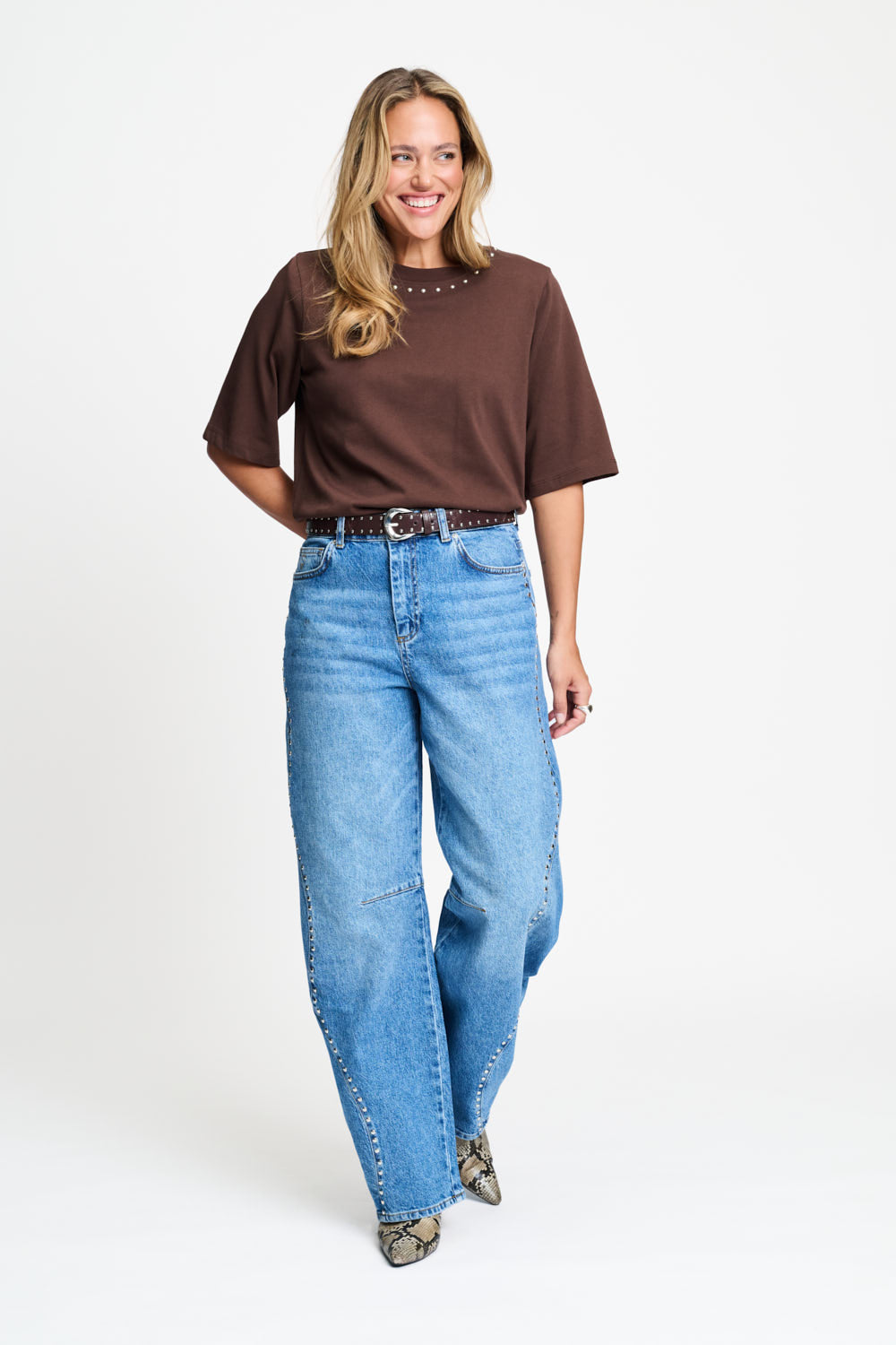 Volledige look met het bruine t-shirt op een wijde lichtblauwe jeans.