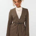 model draagt de ydence lexie blazer in de kleir mud met een zwart ceintuur.
