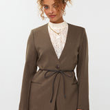 model draagt de ydence lexie blazer in de kleir mud met een zwart ceintuur.
