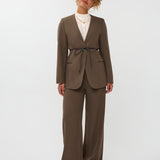 model draagt de ydence lexie blazer in de kleur mud met een zwart ceintuur. hieronder draagt ze de yade pants van ydence.