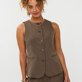 model draagt het mellie gilet van ydence in de kleur mud met de yade pants als co-ord set.