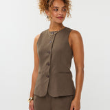 model draagt het mellie gilet van ydence in de kleur mud met de yade pants als co-ord set.