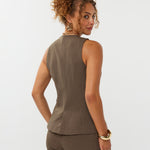 model draagt het mellie gilet van ydence in de kleur mud met de yade pants als co-ord set. Op de foto zie je de achterkant van het gilet.