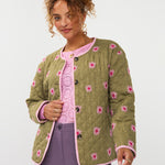 model draagt het ydence jacket robylin in een groene kleur met geborduurde bloemetjes erop.