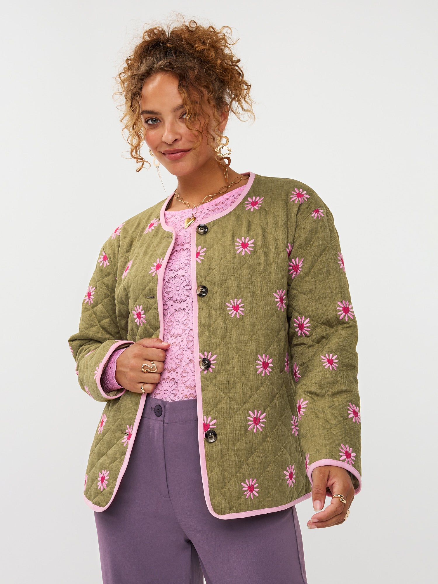 model draagt het ydence jacket robylin in een groene kleur met geborduurde bloemetjes erop.