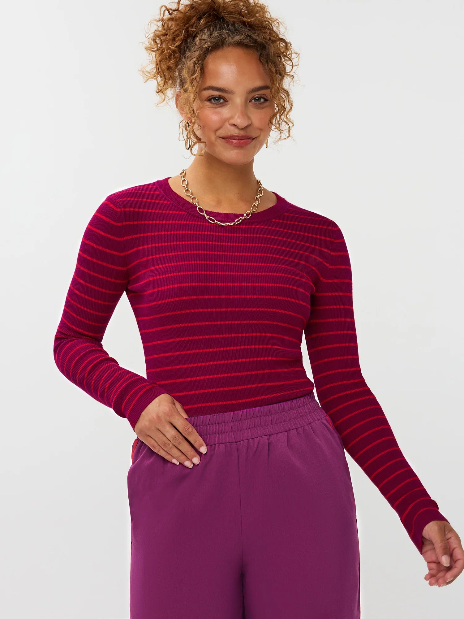 Model draagt de ydence knitted top devina met fuchsia en rode strepen.